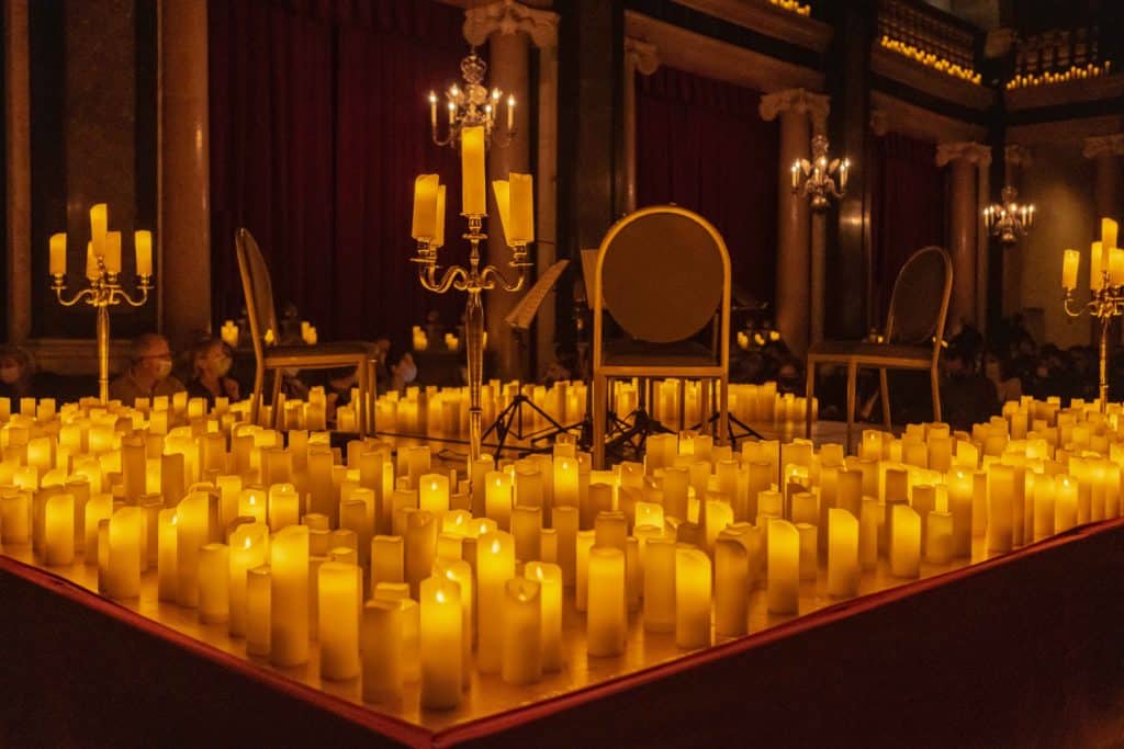 Photo de l'intérieur de la Chapelle de la trinité et gros plan sur la scène avec les bougies et les chaises en velours rouge