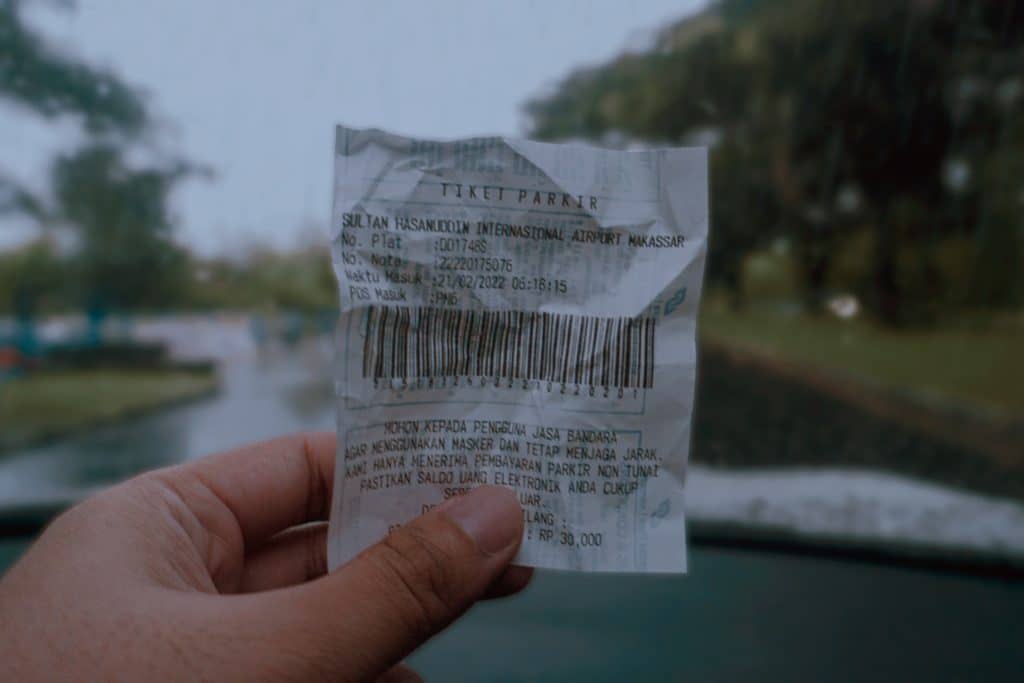 Photo d'une main tenant un ticket de caisse en gros plan avec un fleuve flou en fond